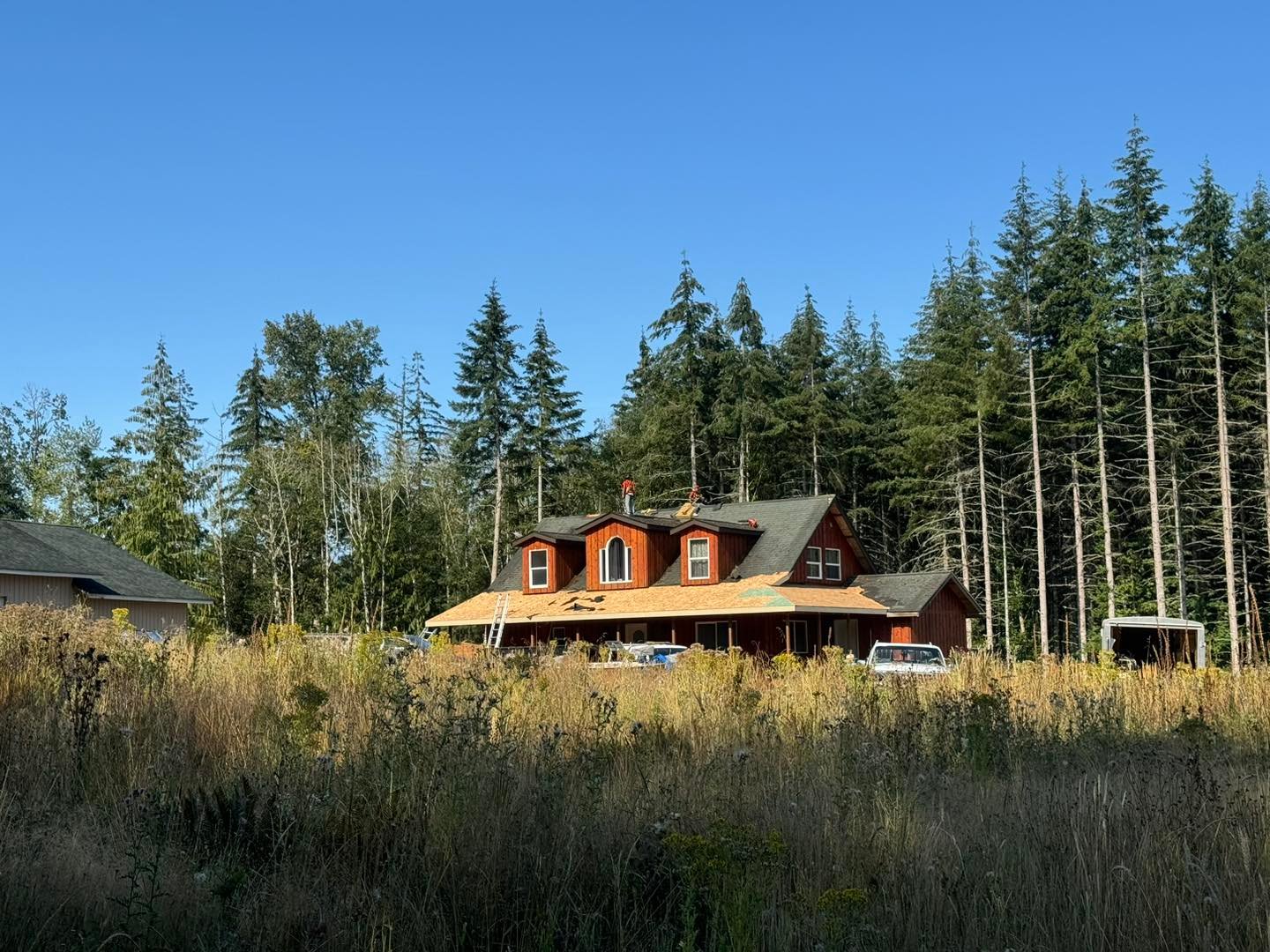 Re-roof in progress on a red cedar-sided home with dormers in Cowlitz County, WA