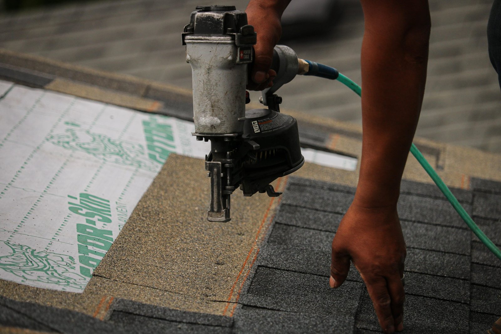 Roofing contractor installing asphalt shingles on residential roof in Longview, WA