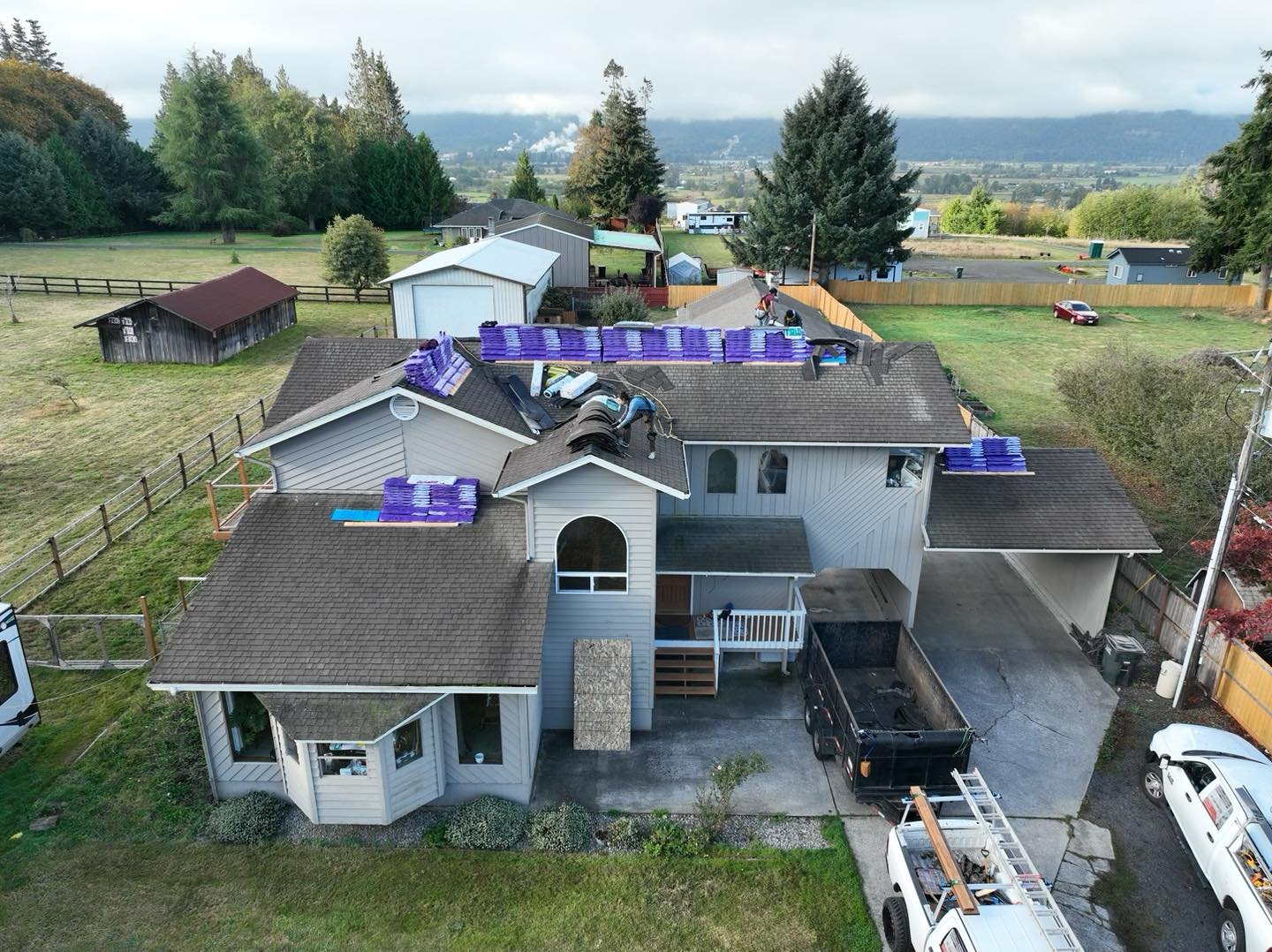 Aerial view of a residential roof replacement in progress with shingle bundles staged on the roof