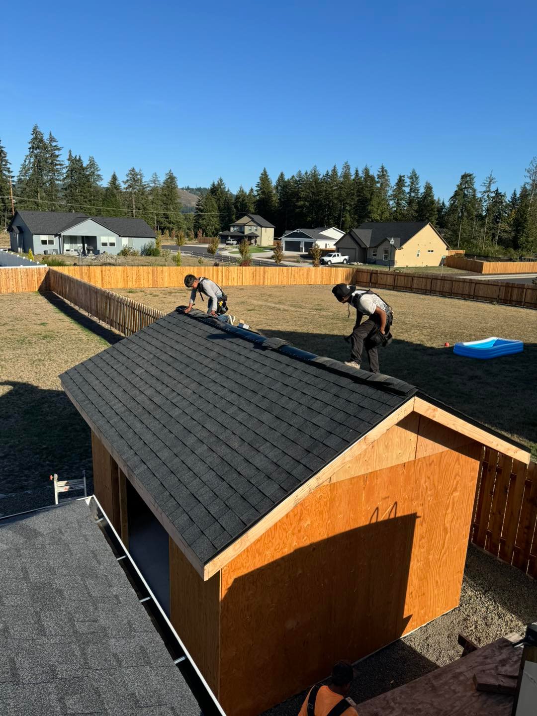 VC Contractor crew installing asphalt shingles on a backyard shed roof in Longview, WA