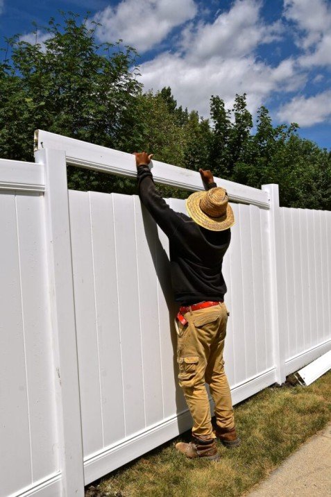 VC Contractor team member finishing a white vinyl privacy fence in Longview, WA